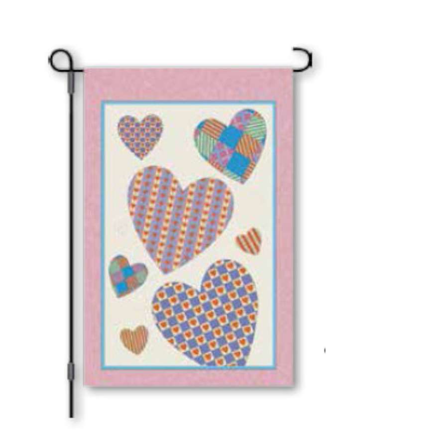 12 in. Amore garden flag displaying a colorful spring design on a flag stand in a garden setting, capturing the essence of the season.