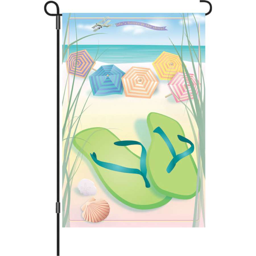 12 in. Better at Shore garden flag featuring a colorful beach scene displayed in an outdoor setting, adding summer vibes to the garden.