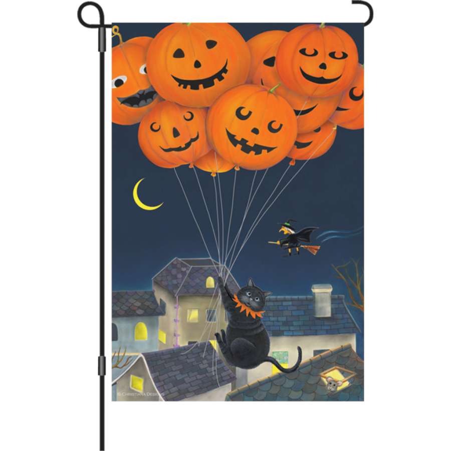 12 in. Black Cat with Balloons garden flag in vibrant colors displayed on an outdoor pole, featuring a cheerful cat surrounded by balloons.