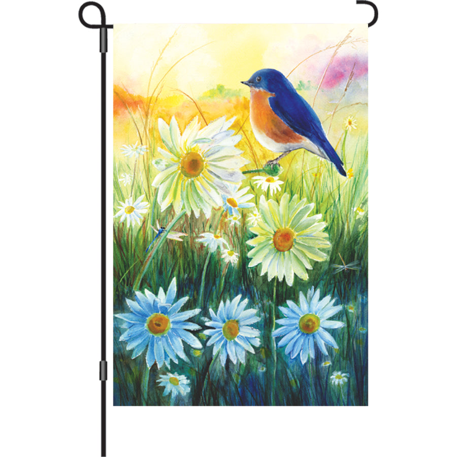12 in. Bluebird Sunrise garden flag with a colorful bluebird design displayed in a garden, showcasing vibrant colors against a sunrise backdrop.