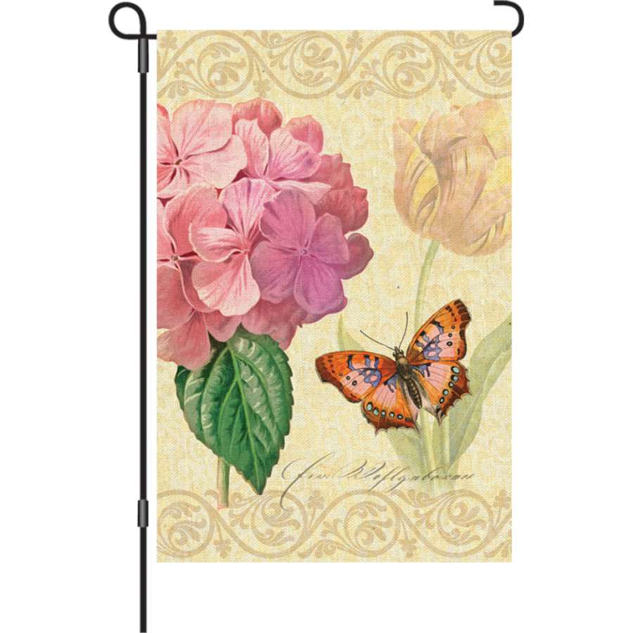 12 in. Botanical Fresh Pink garden flag with bright floral design displayed outdoors, illuminated to enhance its vibrant colors in the light.