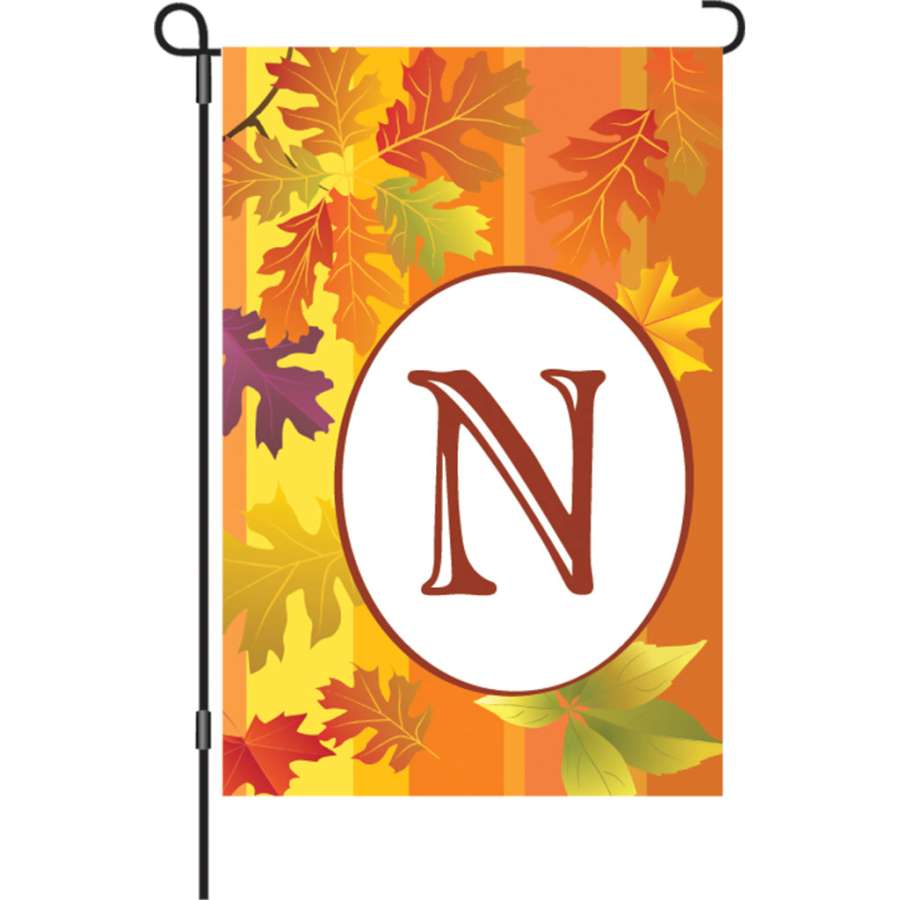 12 in. Fall Monogram Flag featuring vibrant autumn colors and personalized initial, displayed on a garden stand in a scenic setting.