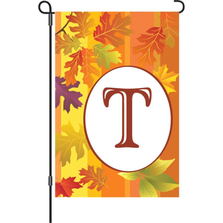 12 in. Fall Monogram Flag - T displayed in a garden setting, showcasing vibrant autumn colors and a stylish letter monogram design.