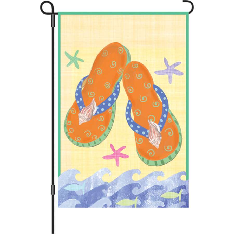 12 in. Orange Flip Flops garden flag featuring a colorful flip flop design, displayed in an outdoor garden setting with a bright sunny backdrop.