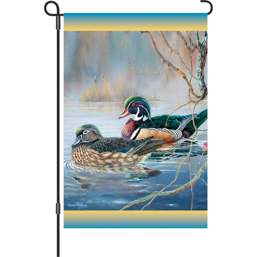 12 in. illuminated garden flag with colorful Woodies Bobber design displayed in a garden setting, offering flickering light at dusk.