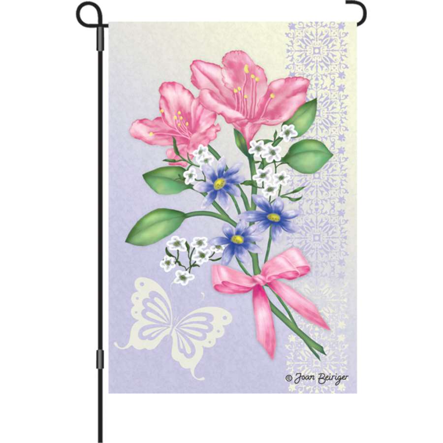 Illuminated 12 in. Freesia Elegance garden flag displayed in an outdoor setting, showcasing vibrant freesia flower designs.