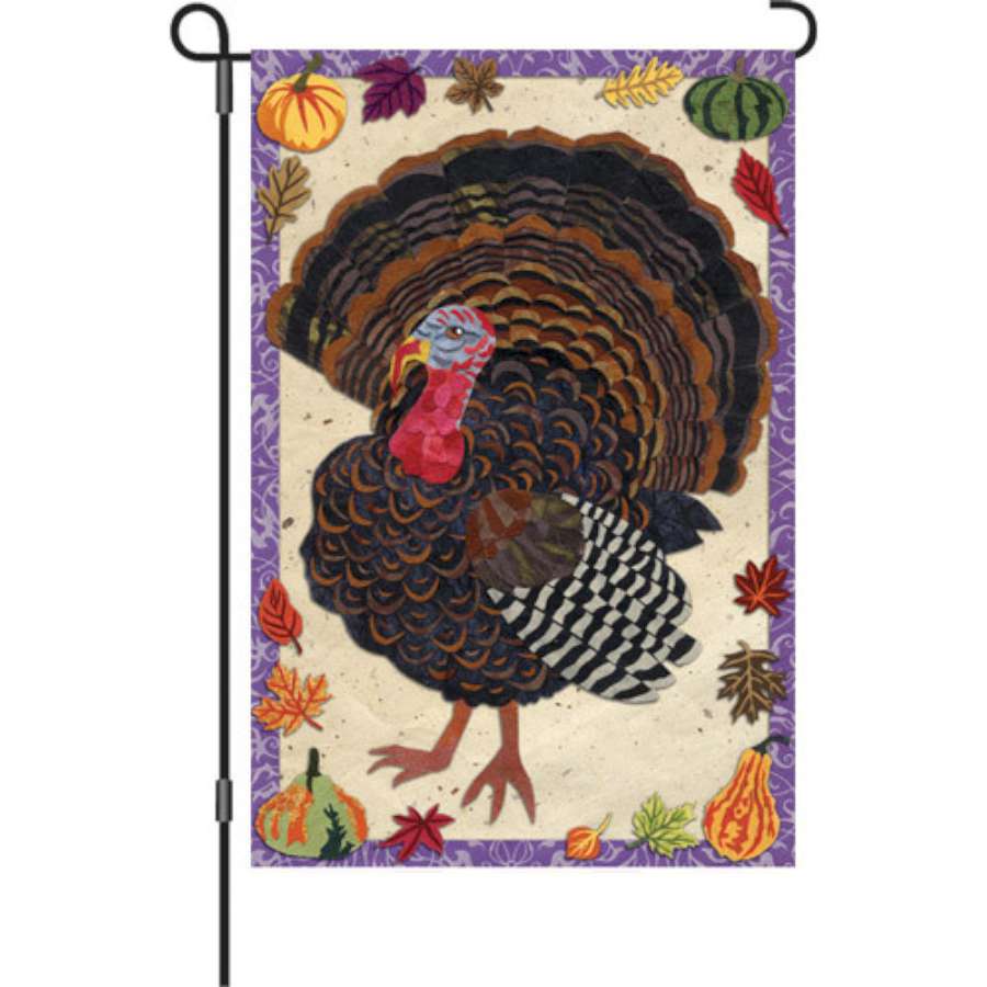 12 in. Textured Turkey garden flag showcasing a detailed turkey design, fluttering gently on a decorative pole in a fall garden.