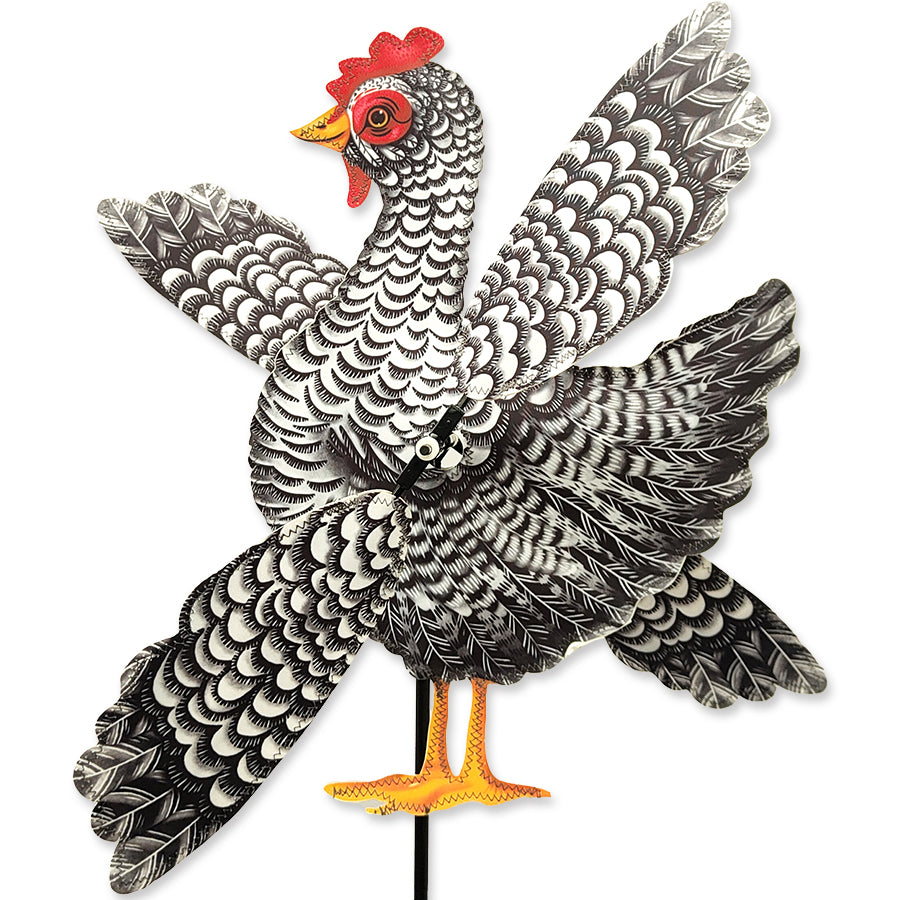 12 in. WhirliGig Spinner featuring a whimsical chicken design, spinning cheerfully in a garden setting on a sunny day.