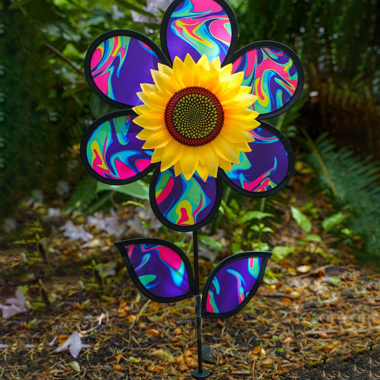 12\" Blue Psychedelic Sunflower garden spinner with colorful petals in motion, surrounded by greenery, enhancing outdoor aesthetics.