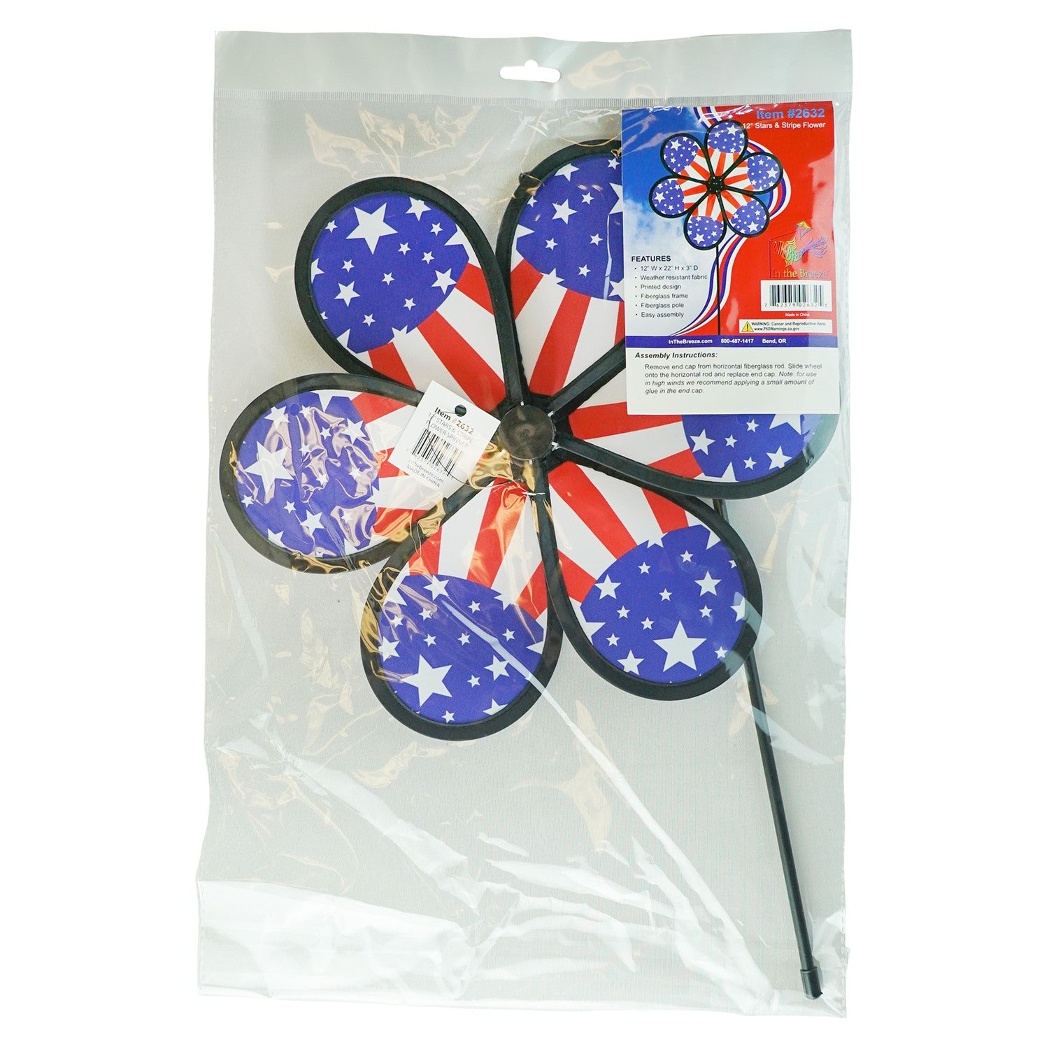 12-inch Patriot Star Flower Spinner with a vivid Stars and Stripes design, spinning on a garden pole in an outdoor setting.