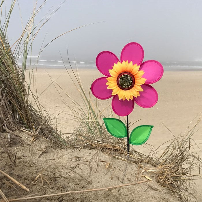 12-inch pink sunflower spinner featuring vibrant petals and realistic center displayed in a garden setting with a fiberglass pole.