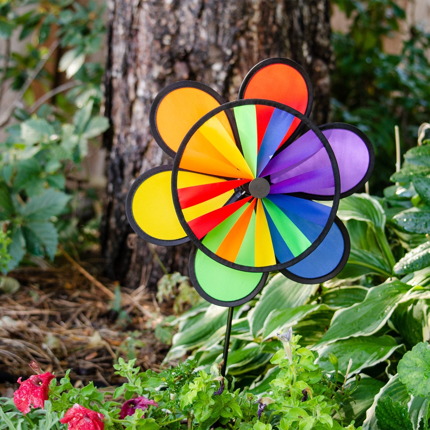 12-inch Rainbow Double Flower Wheel Combo wind spinner with vibrant colors, spinning gracefully in an outdoor garden setting.