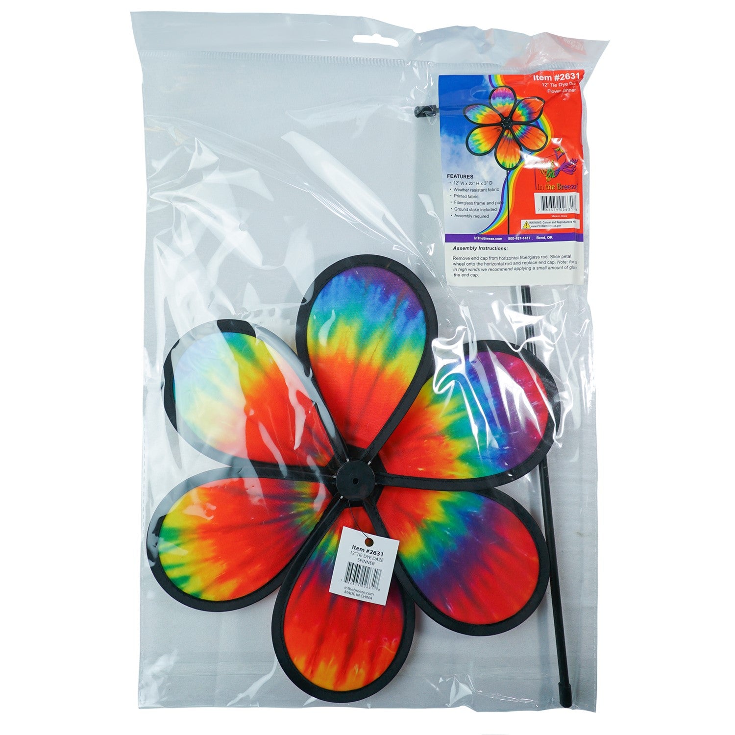 Colorful 12\" Tie Dye Daze Flower Spinner displaying vibrant tie-dye colors, spinning in a sunny garden setting, showcasing its whimsical design.