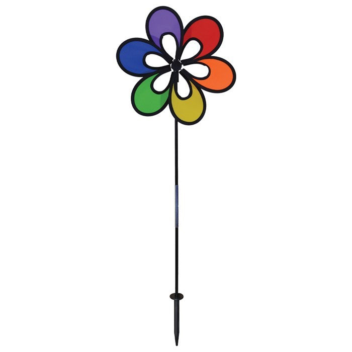 Colorful 12" Rainbow Windee Wheelz Spinner with petal design, set against a bright blue sky in a garden setting, showcasing its vibrant hues.