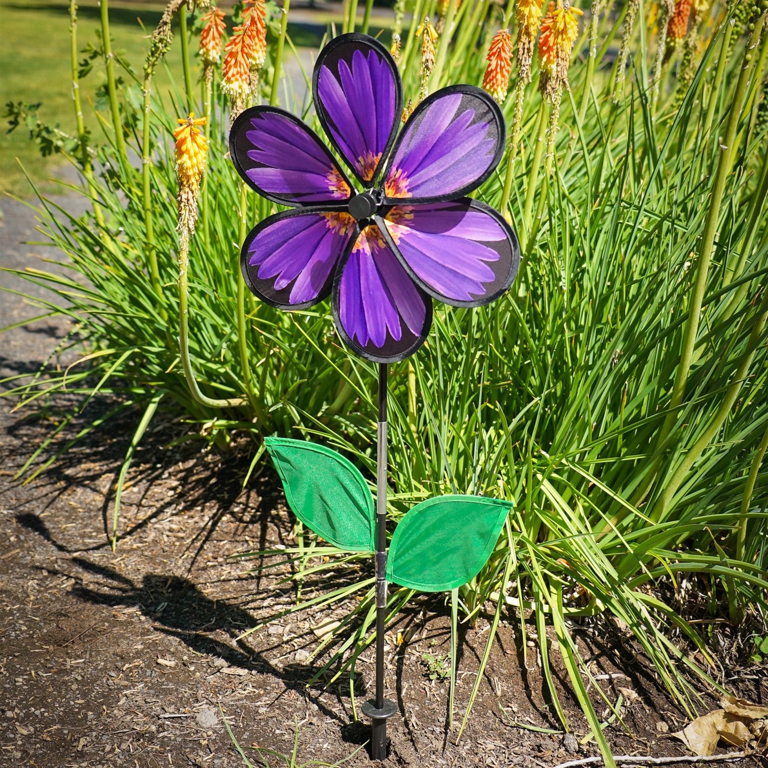13.5-inch Aster Spinner with vibrant petals and green leaves, showcasing realistic flower design in an outdoor garden setting.