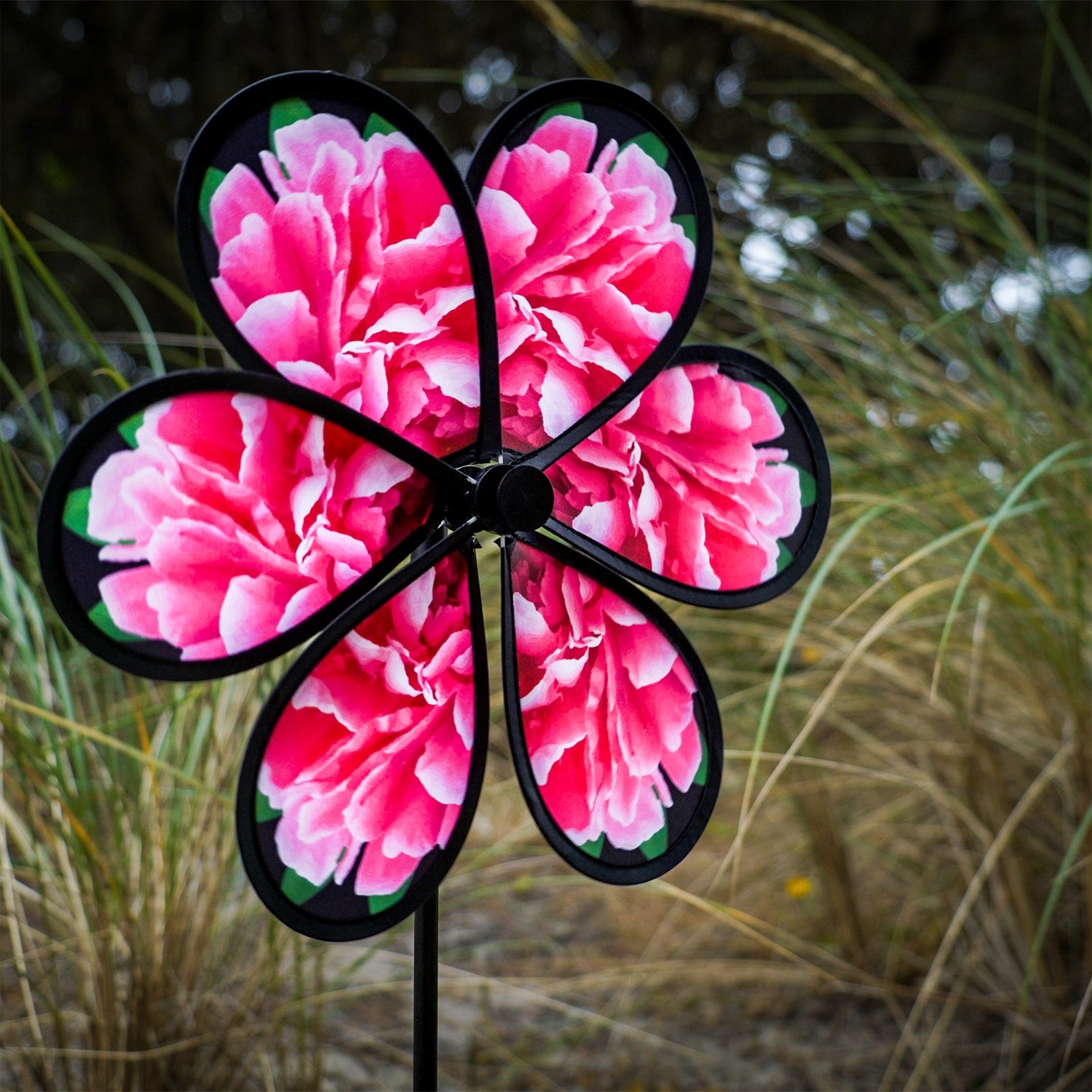 13.5 inch Peony Spinner with realistic printed petals and green leaves spinning in a charming outdoor garden setting.
