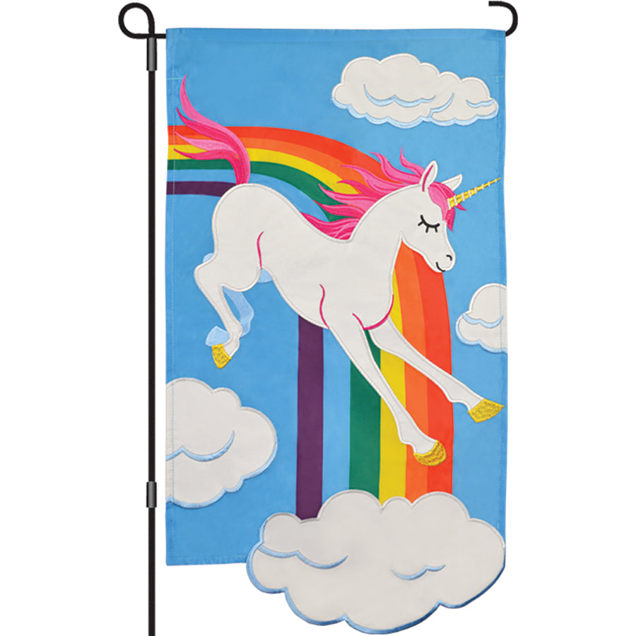 13 in. Enhanced Flag featuring a colorful embroidered applique Rainbow Unicorn design, displayed prominently in a garden setting.
