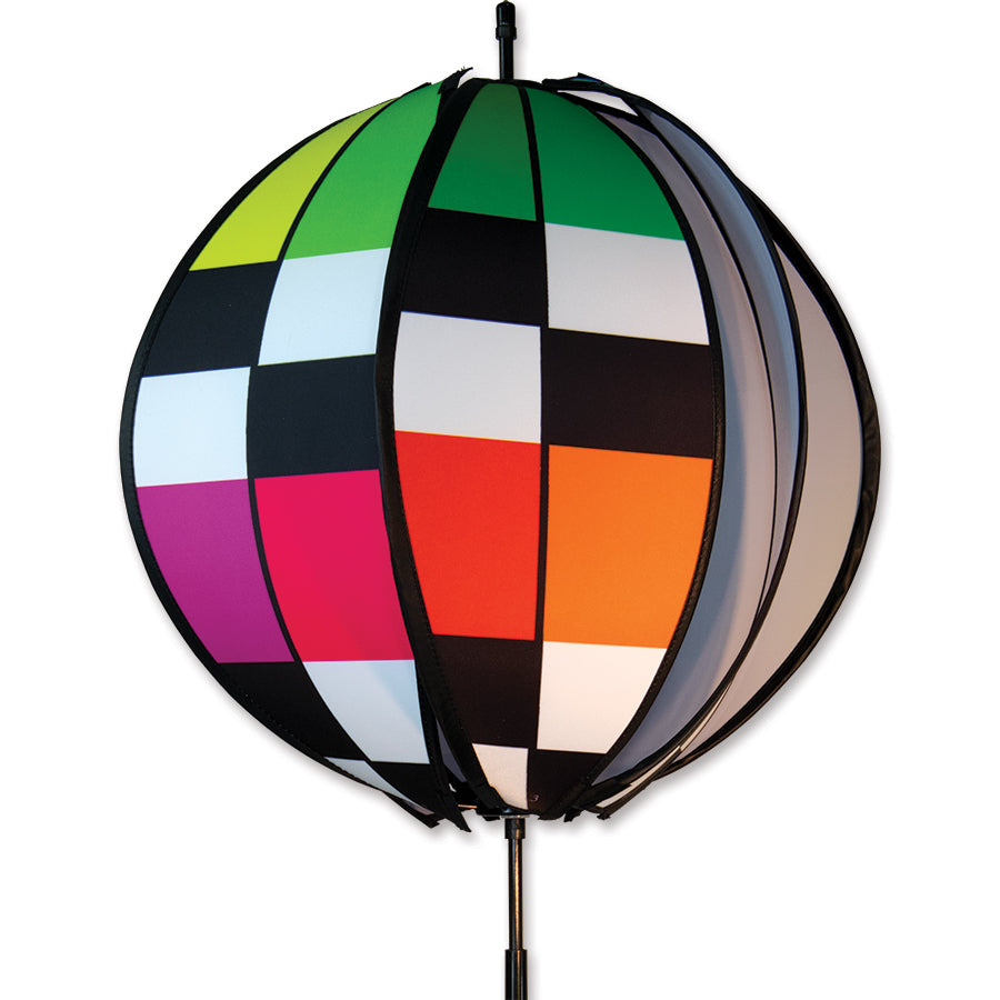 15 in. Ball Spinner featuring a rainbow checkerboard design, displayed outdoors on a sunny day, spinning lazily in the breeze.