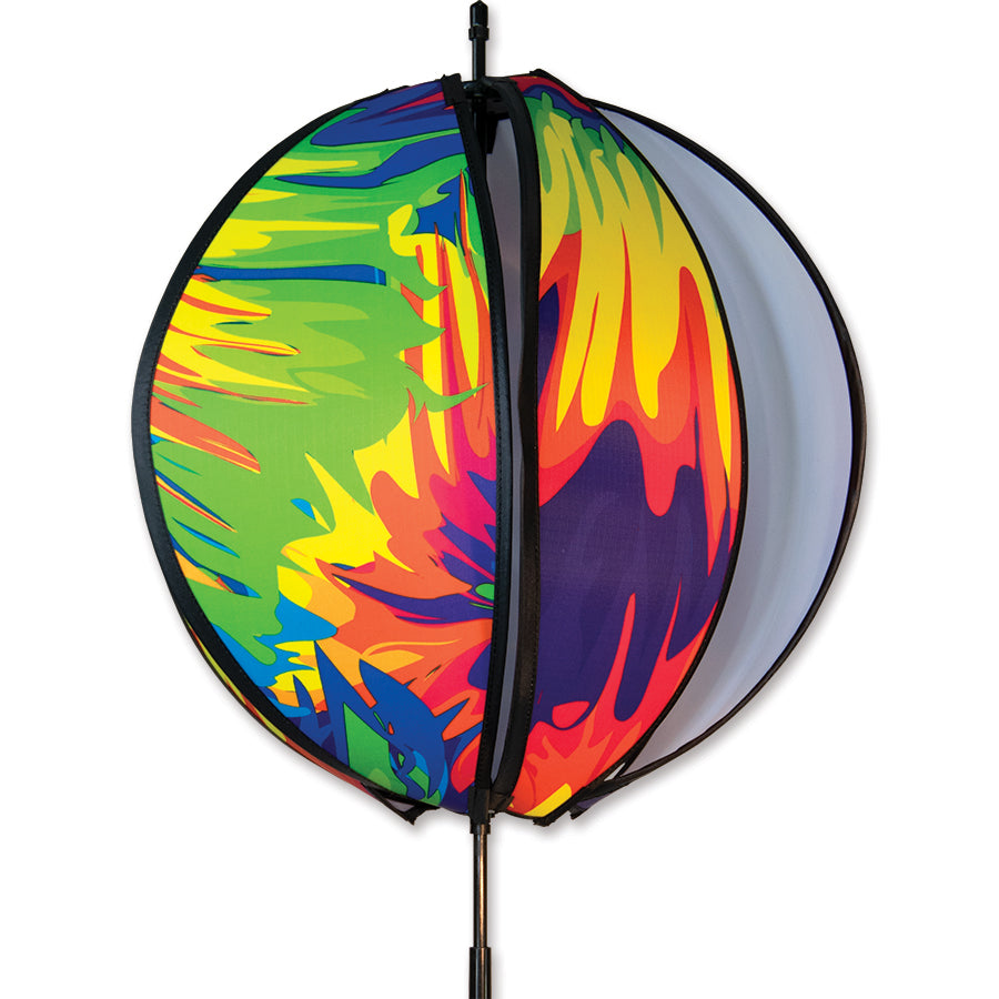 15 in. Ball Spinner - Tie Dye featuring six colorful panels on a stake, gracefully spinning in a lush garden setting, showcasing vibrant colors.