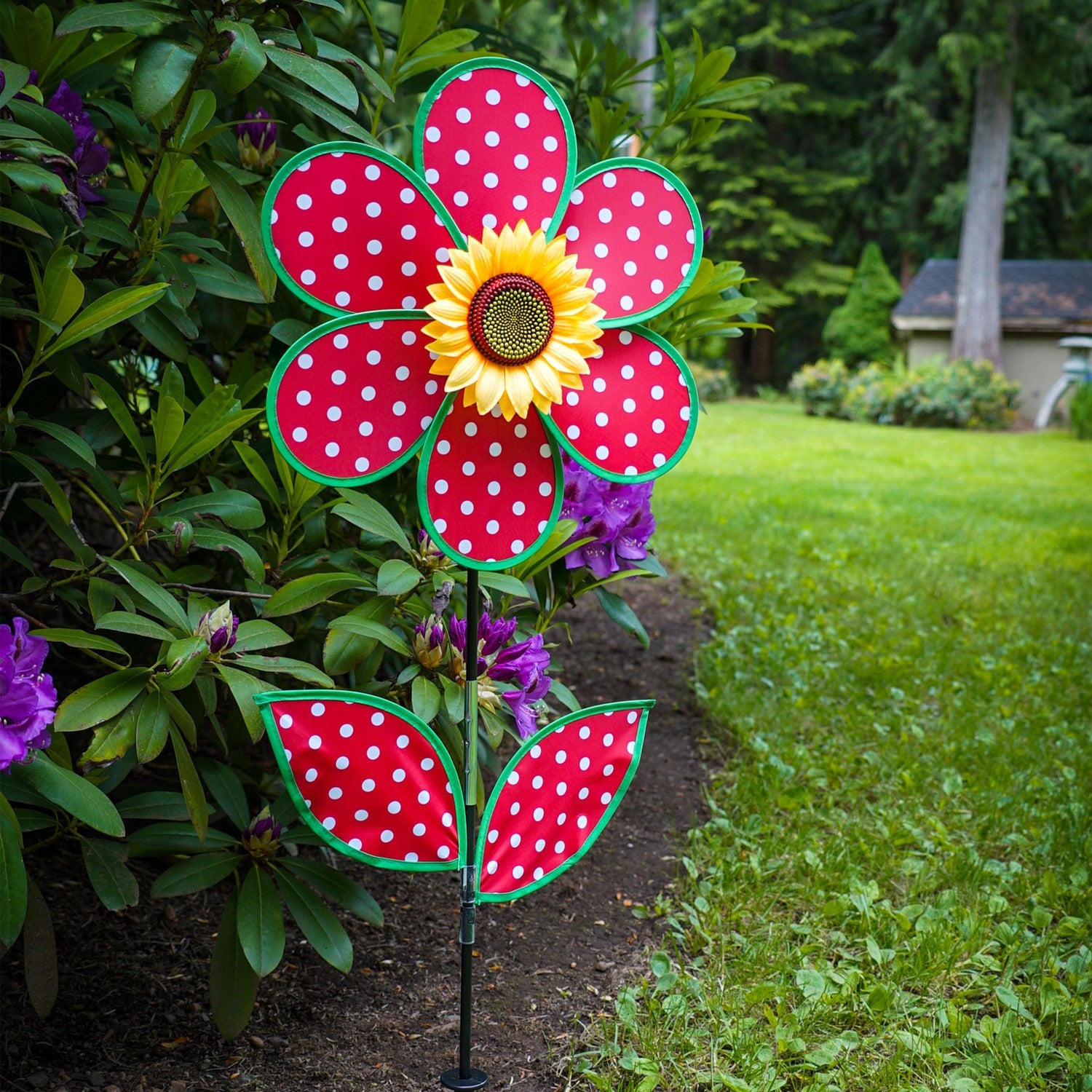 16" Polka Dot Flower with Leaves garden spinner featuring red and white polka dot petals and a sunflower center, displayed outdoors.