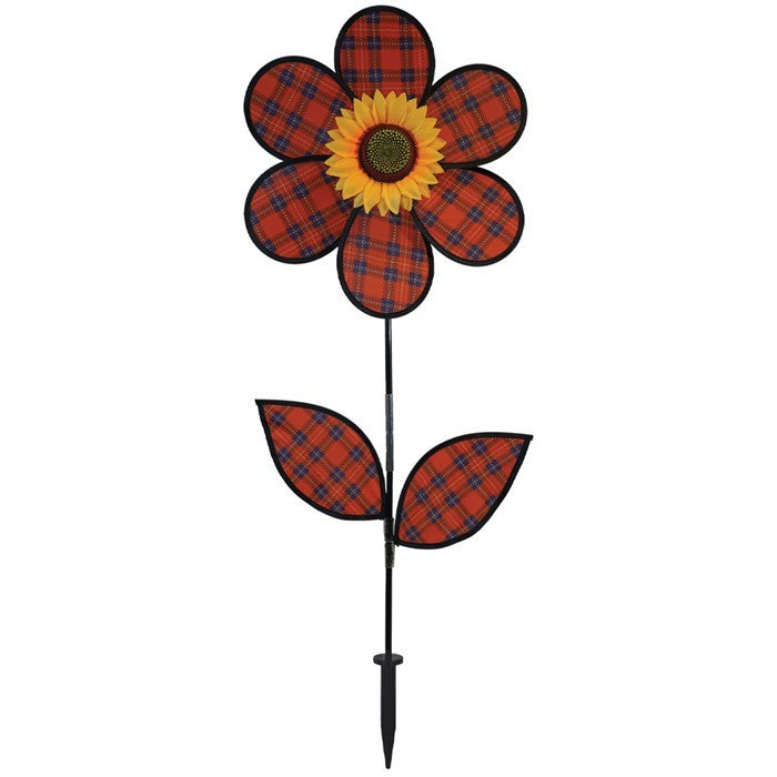 A vibrant 16-inch Red Plaid Flower Spinner with lush green leaves and a sunflower center, rotating gracefully in a garden setting.