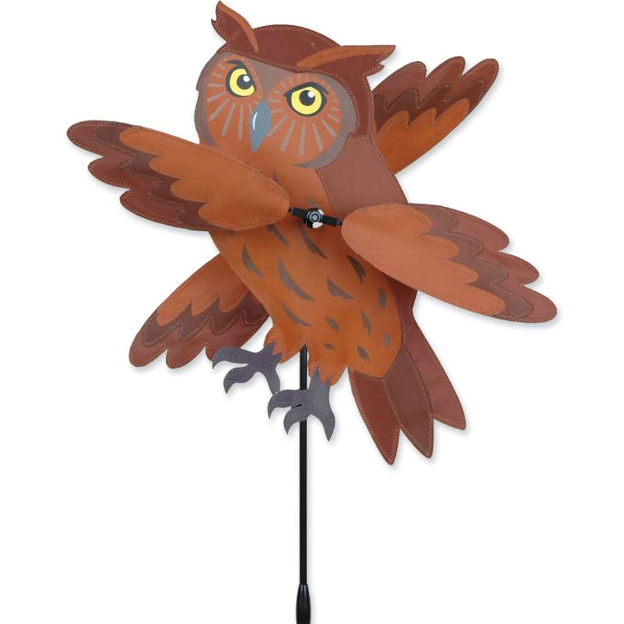 17 in. WhirliGig Spinner featuring a colorful brown owl design, spinning in the breeze, beautifully enhancing a garden setting.