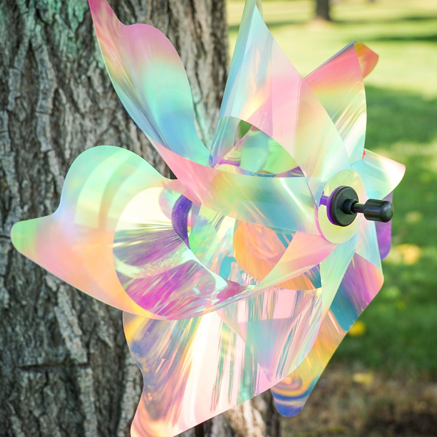 18-inch striped iridescent pinwheel spinner made of durable Mylar, vibrant pastel colors, displayed outdoors in a garden setting.