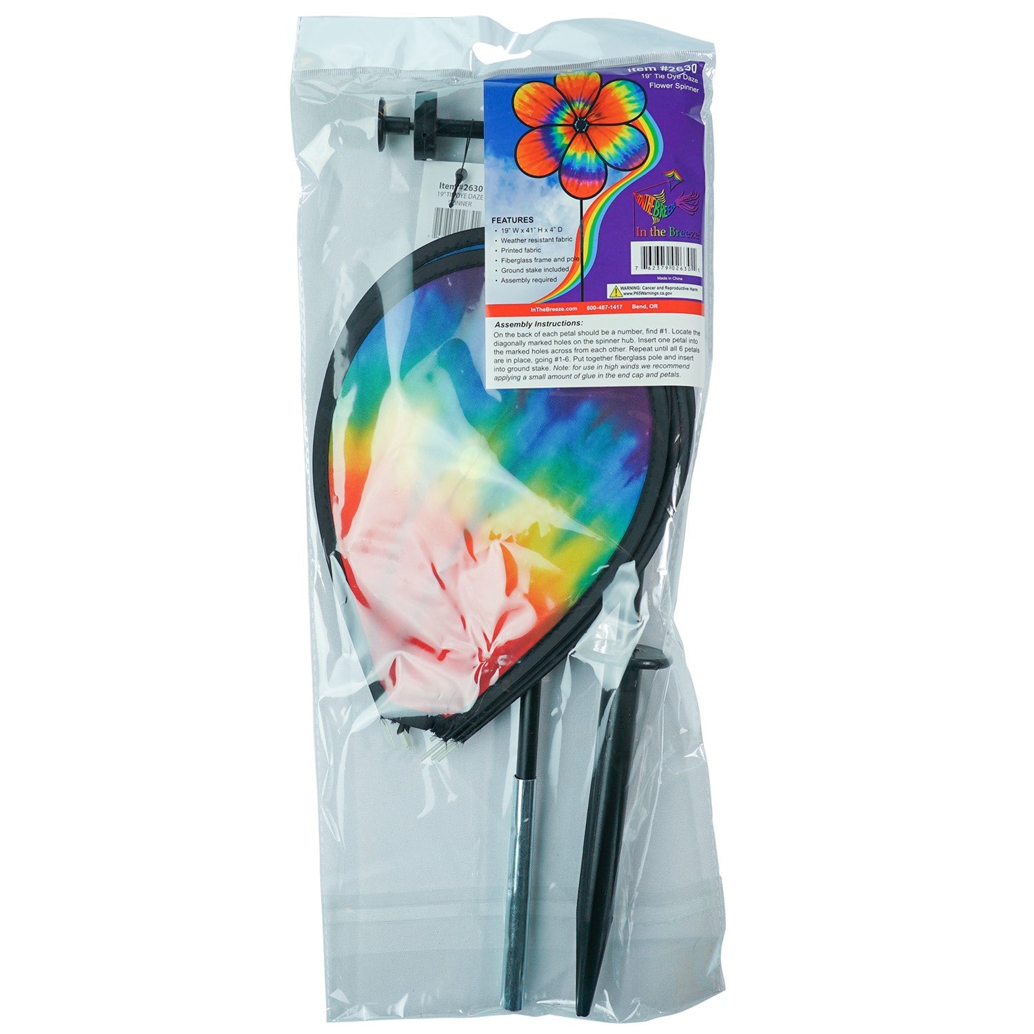 Colorful 19\" Tie Dye Daze Flower Spinner with psychedelic tie-dye design on a garden pole, creating a charming spiral effect in the breeze.