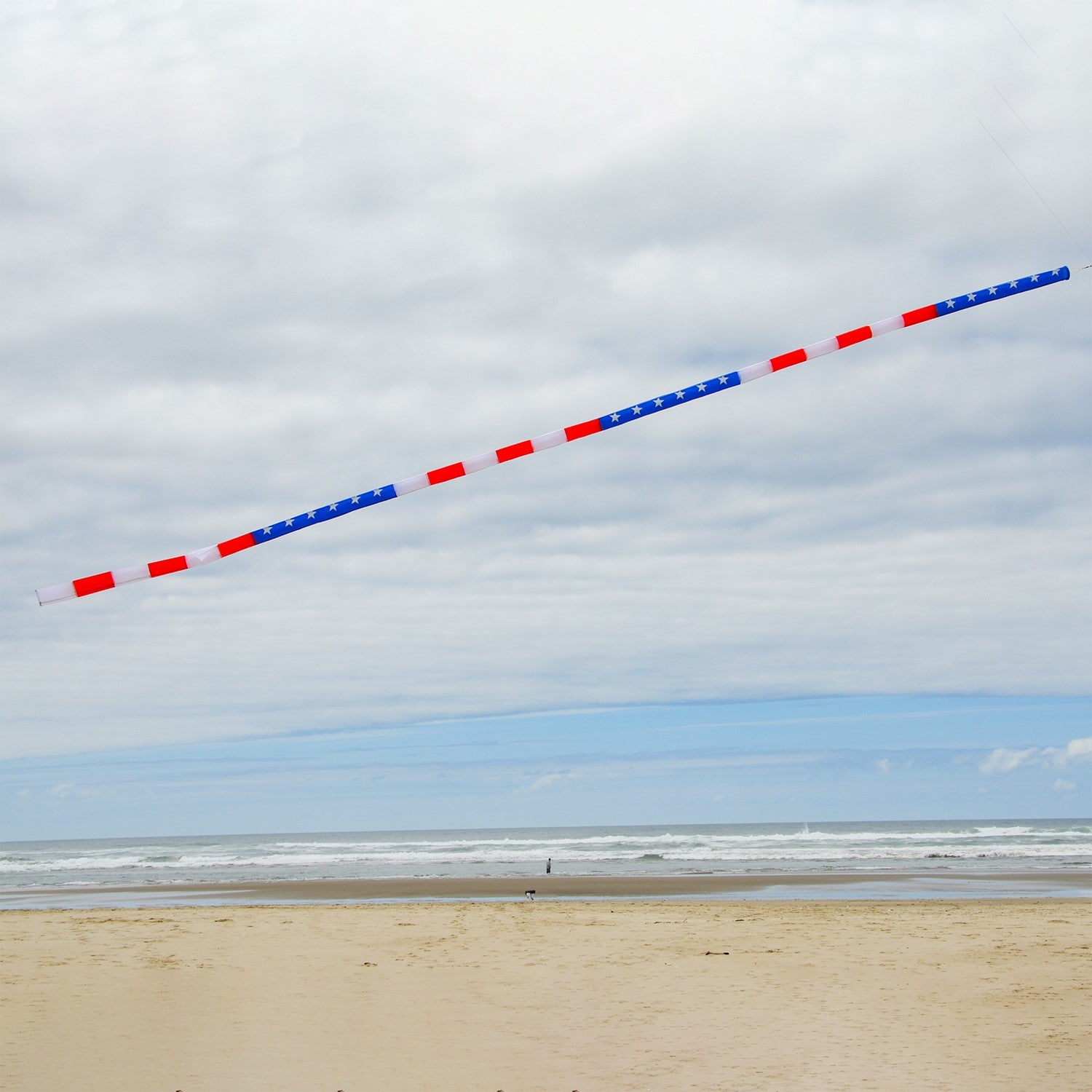20-foot Patriotic Tube Tail featuring red, white, and blue stars and stripes, soaring high with an inflatable design attached to a kite.