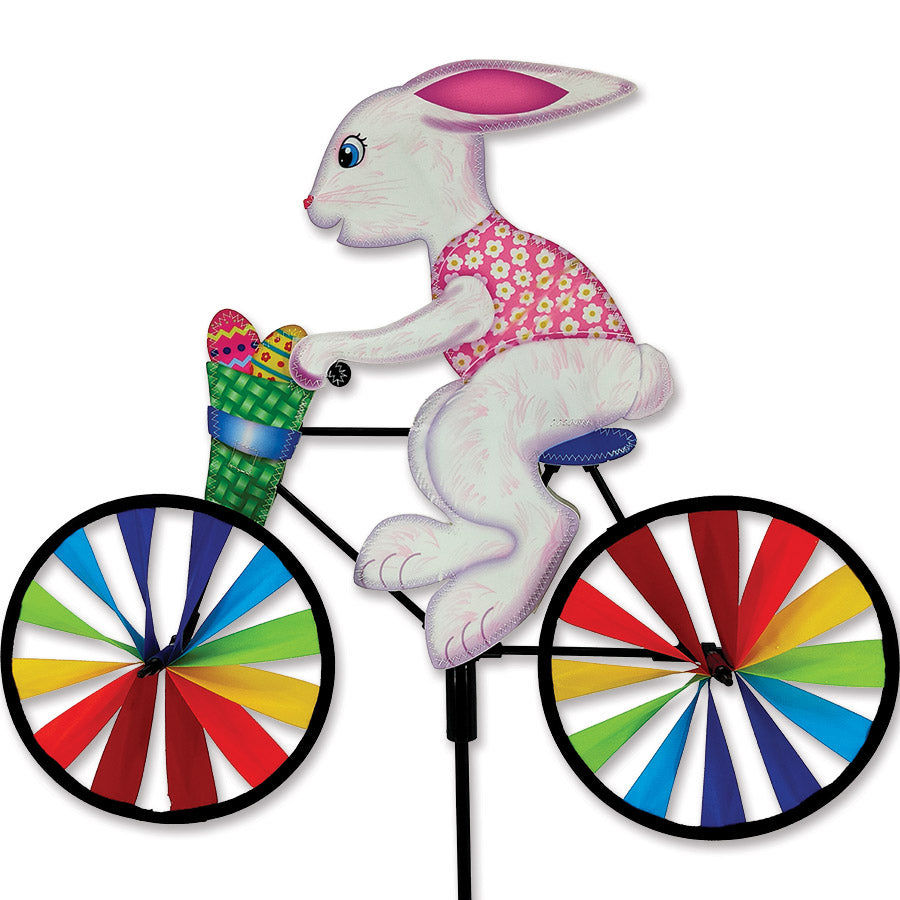 20 in. Bike Spinner featuring a colorful Easter Bunny design, spinning in the garden against a clear blue sky.