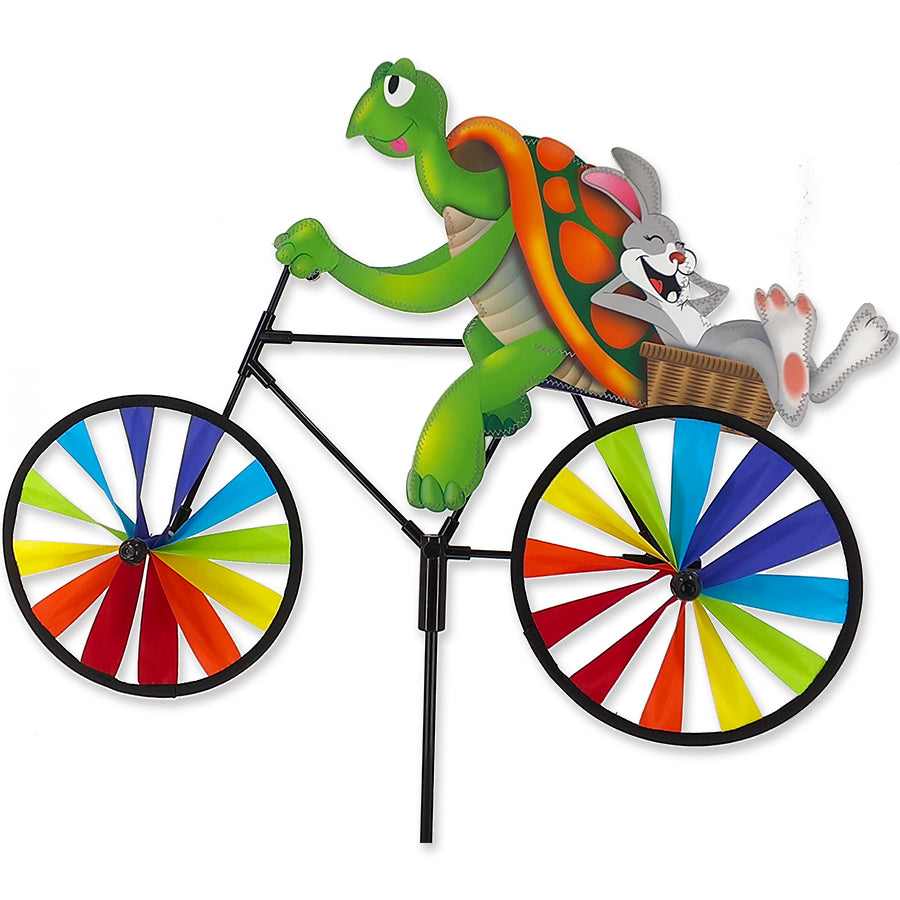 20 in. Bike Spinner featuring tortoise and hare design, brightly colored and spinning gracefully in a garden setting.