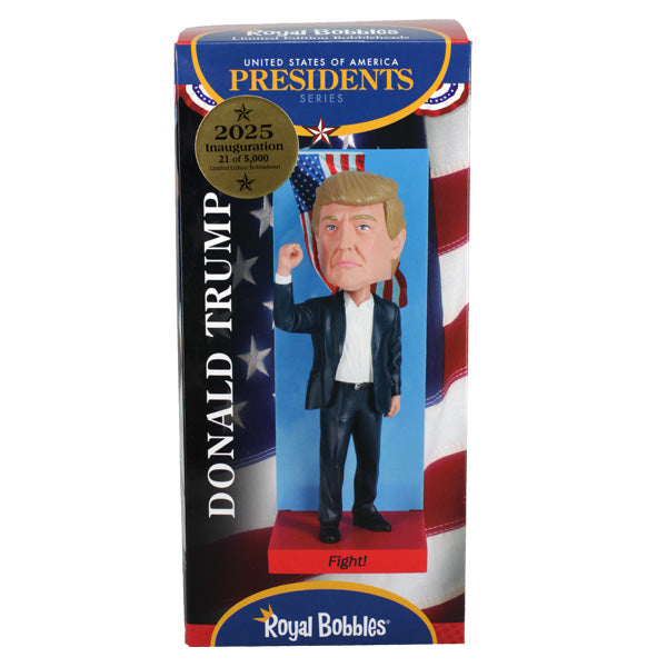 2025 Inauguration Limited Edition Donald Trump Bobblehead featuring a raised fist and American flag backdrop displayed on a shelf.
