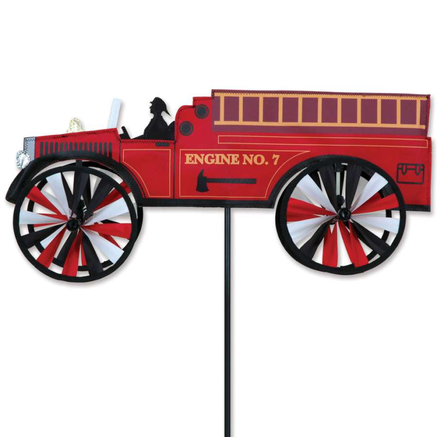 21 in. Fire Truck Spinner displayed in a garden, featuring a colorful design that spins in the breeze, adding cheerful movement to the outdoor space.