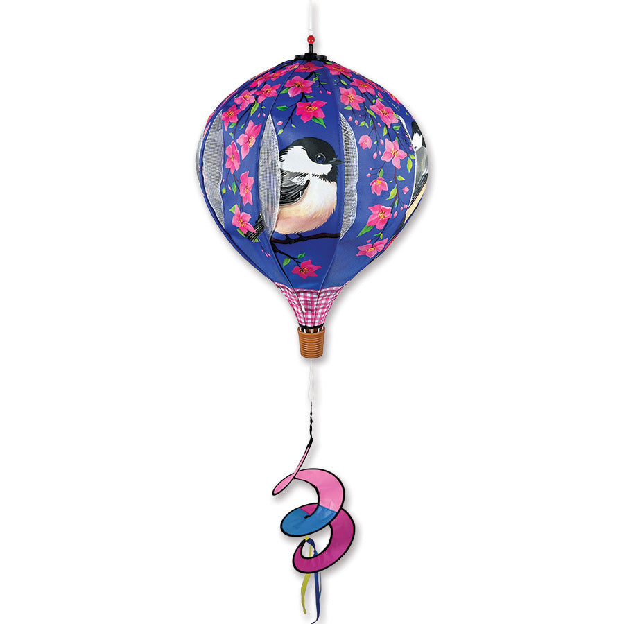 22 in. Pop-Open Hot Air Balloon in Chickadee design spins gently in the wind, displaying vibrant colors against a serene outdoor setting.