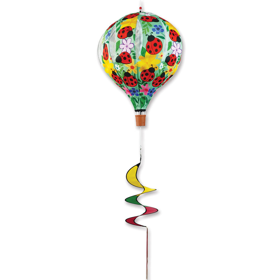 22 in. Pop-Open Hot Air Balloon in floral ladybug design, spinning gently in the breeze on a sunny deck, enhancing outdoor decor.