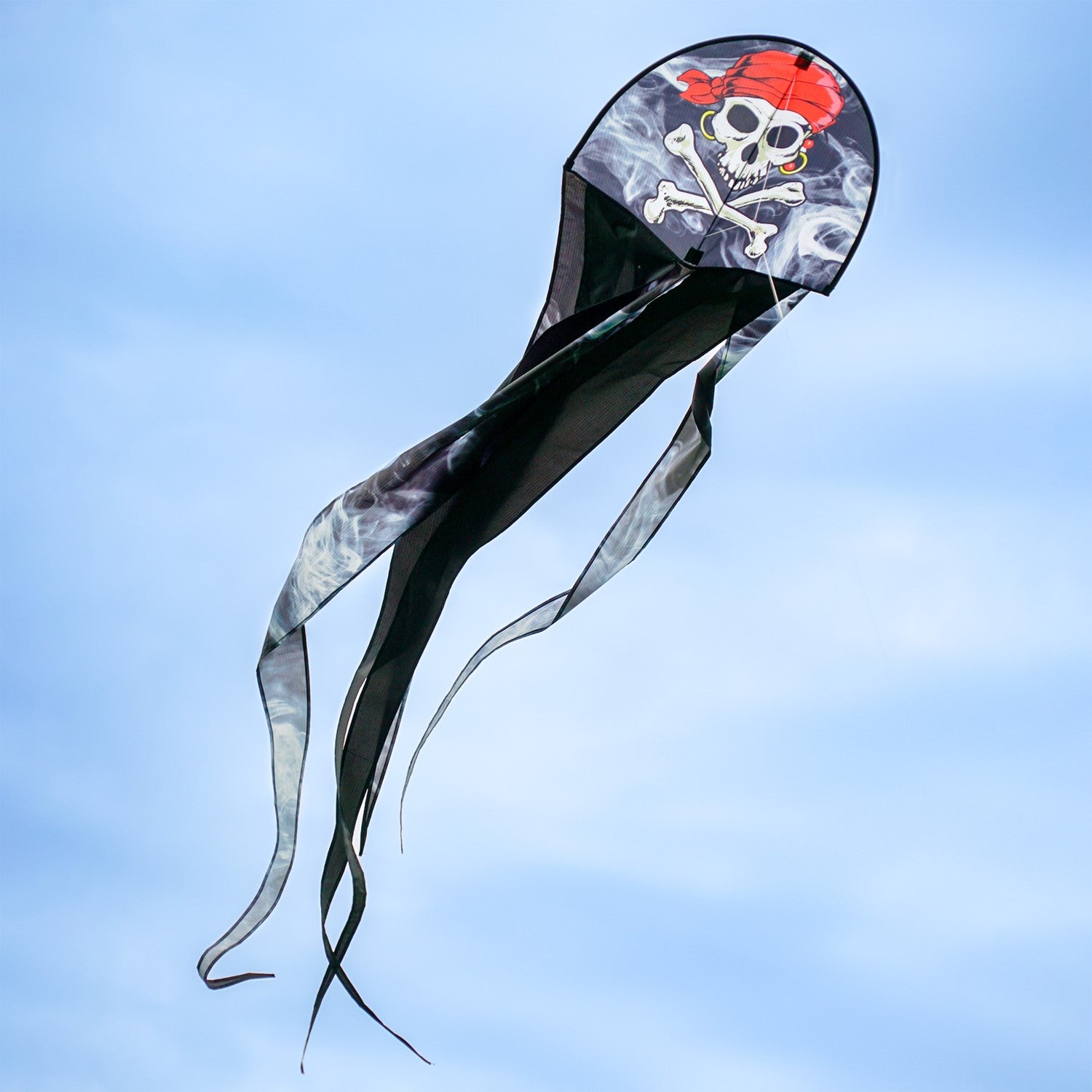 22 inch Smokin' Pirate Dancing Dragon Kite flying in the air with vibrant pirate and dragon designs, showcasing long flowing tails in a clear sky.