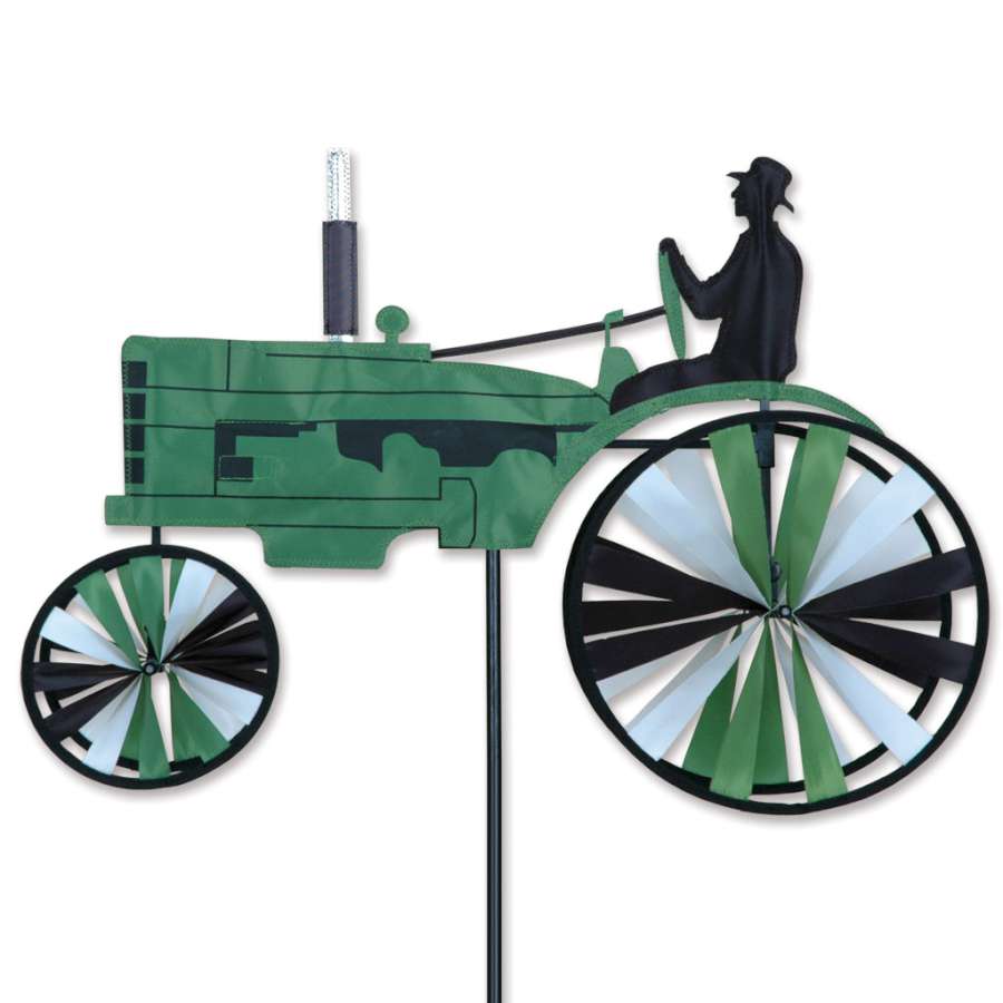 23 in. Old Tractor Spinner in green featuring vintage tractor design, spinning gently in a garden setting filled with flowers.