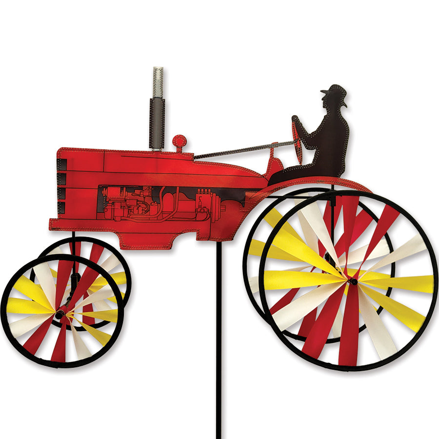 23 in. Old Tractor Spinner featuring a vintage red tractor design, spinning in a sunny garden setting among colorful flowers.