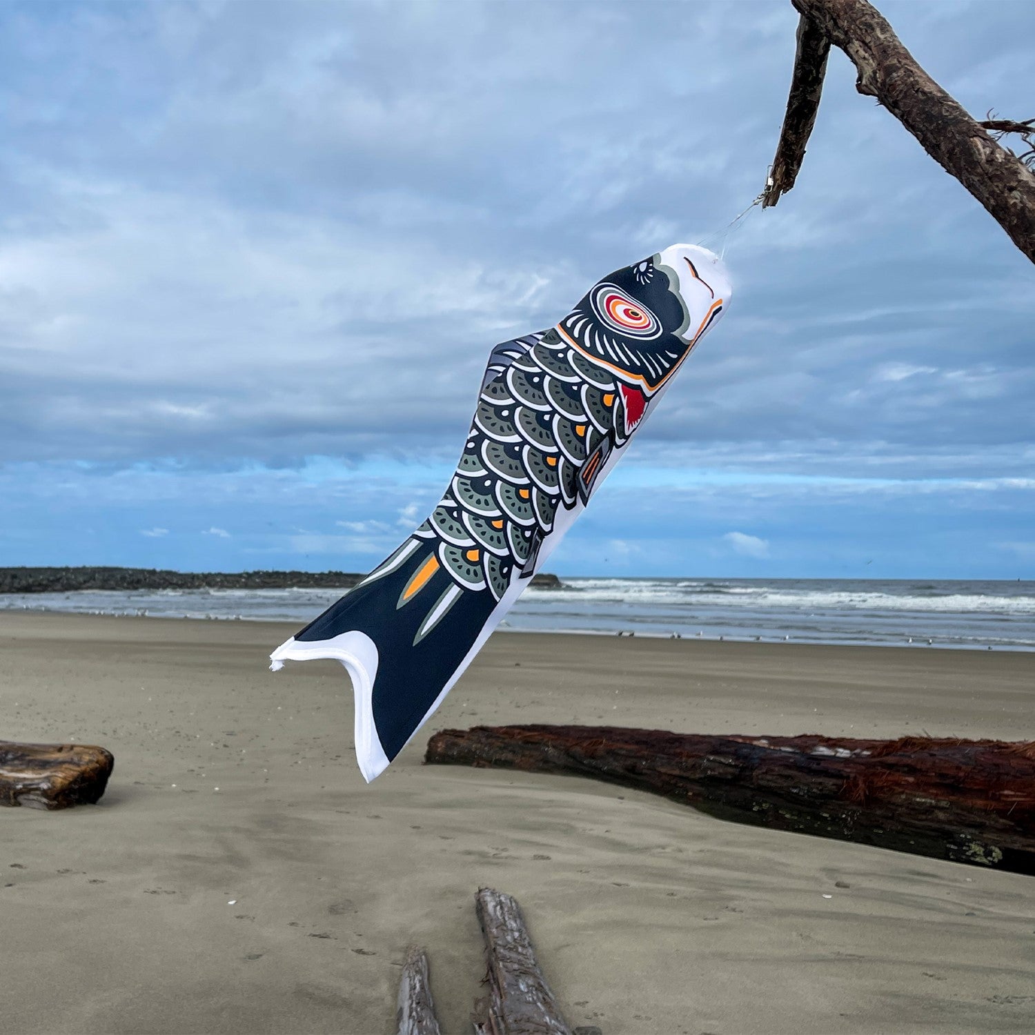 Vibrant 24-inch Black Koi windsock swaying gently in the breeze, showcasing intricate patterns against a clear blue sky.