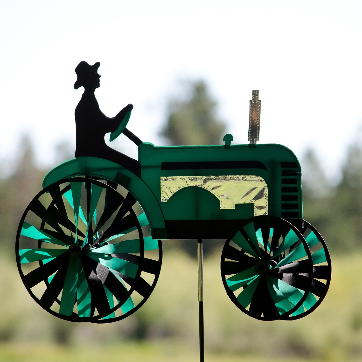 24-inch Green Tractor Spinner with four spinning wheels, vibrant design, and fiberglass frame displayed in a sunny garden setting.