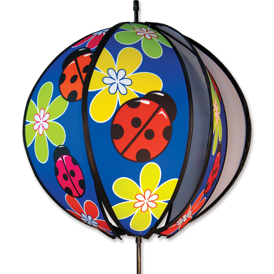 24 in. Ball Spinner featuring colorful ladybugs, rotating in a garden setting with a ground stake firmly in place.