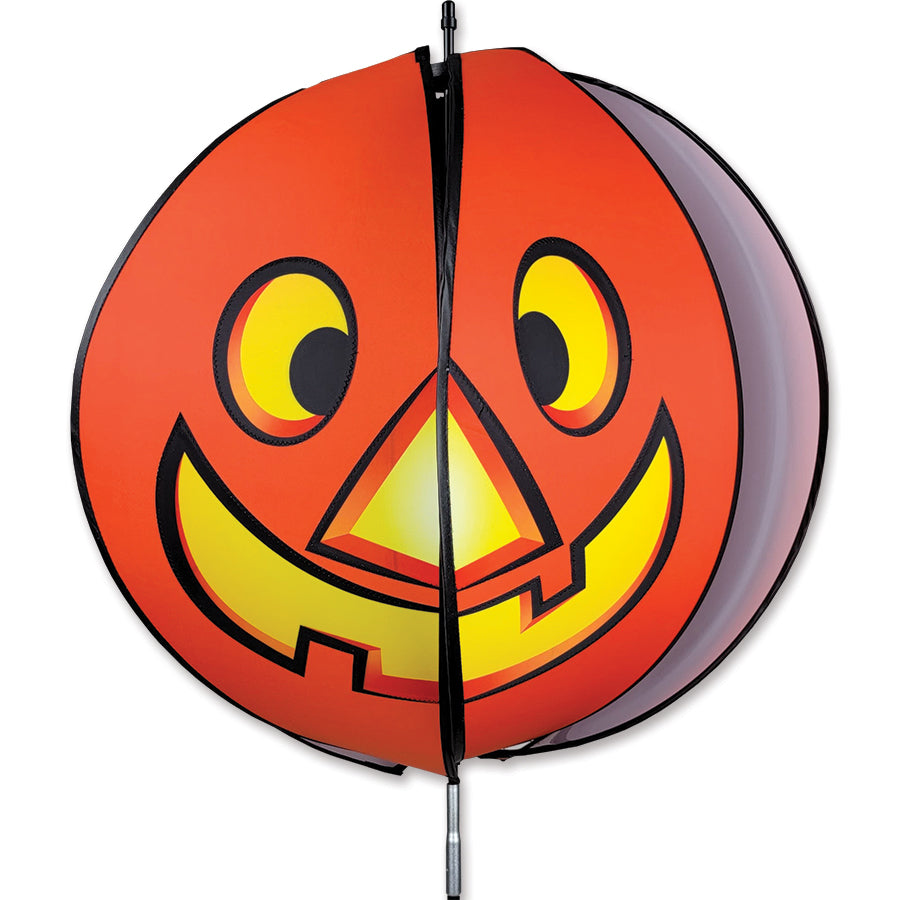 24-inch Pumpkin Spinning Head featuring a happy face on one side and a spooky face on the other, displayed in a garden.