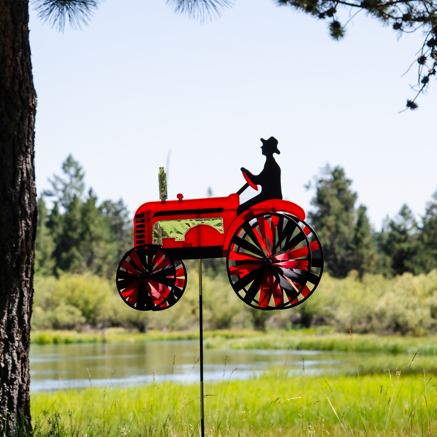 24-inch Red Tractor Spinner with four vibrant spinning wheels and applique details, delightfully showcased in an outdoor garden setting.