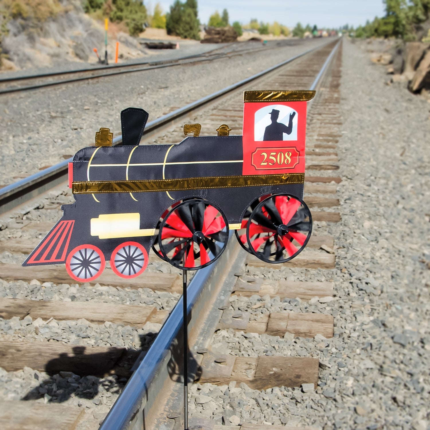 24-inch Steam Engine Spinner with vibrant colors and shiny applique accents, spinning gently in a garden setting, evoking retro train nostalgia.