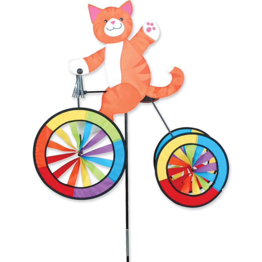Vibrant 25 in. Tricycle Spinner with colorful design and shiny silver tassels displayed in a garden, spinning gently in the breeze.
