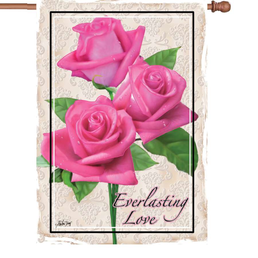 28 in. Everlasting Love house flag featuring a vibrant heart design, displayed on a flagpole in a sunny garden setting.