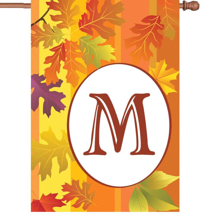 28 in. Fall Monogram Flag - M displayed outside a home with autumn leaves, featuring rich colors and a prominent letter design.