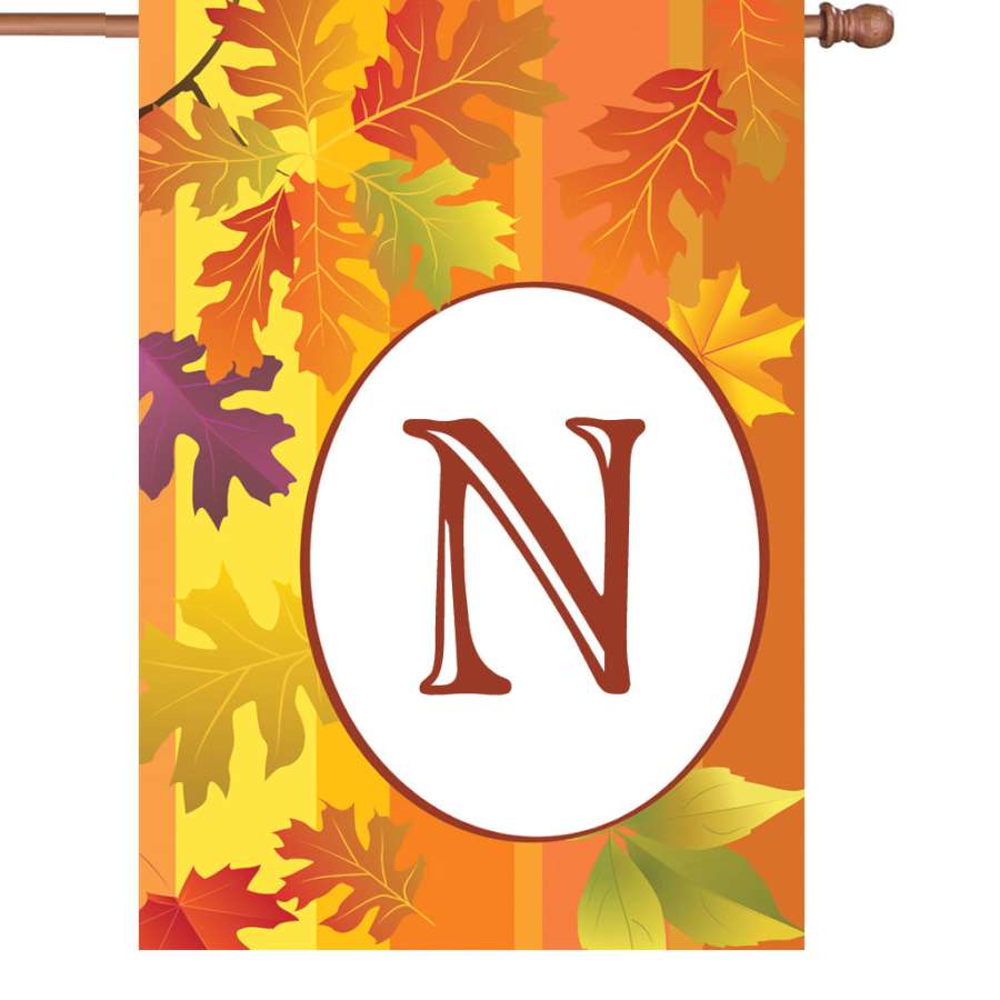 28 in. Fall Monogram Flag - N featuring autumn colors and monogrammed design displayed on an outdoor flagpole in a garden setting.
