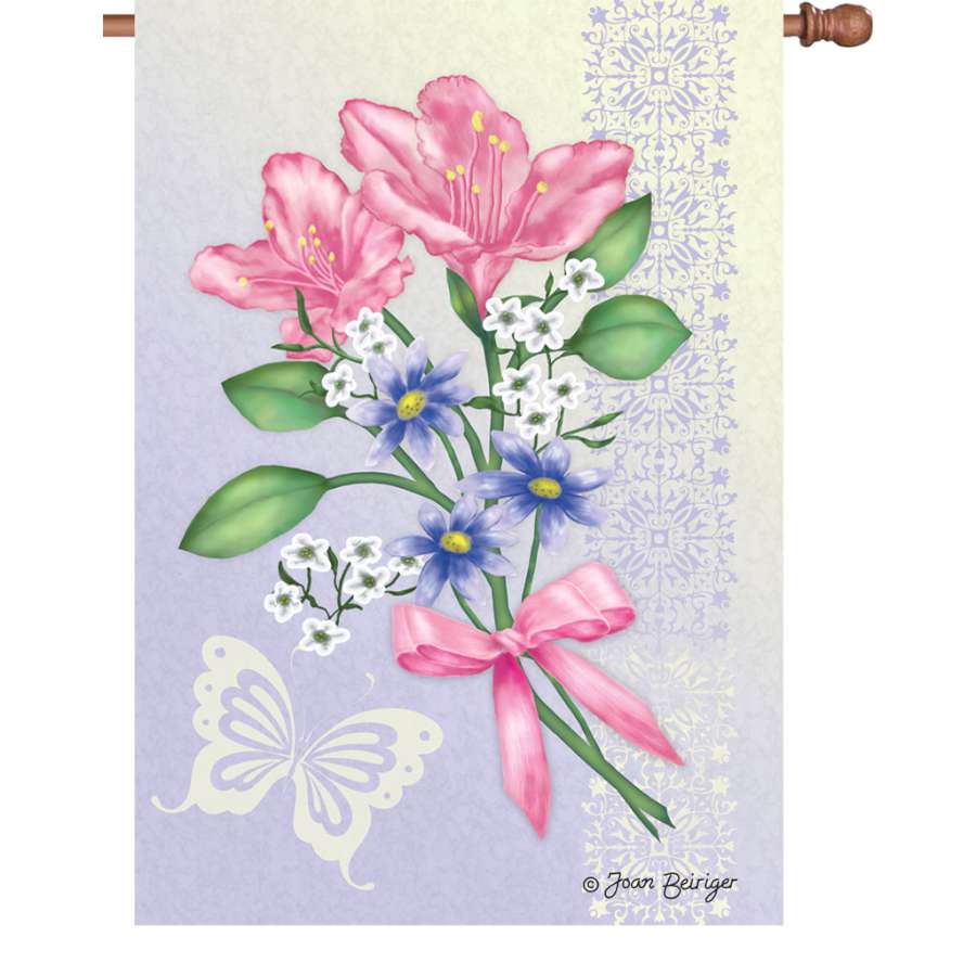 28 in. Flag - Freesia Elegance displays a vibrant freesia floral design, illuminated and flowing on a flag pole in a garden setting.
