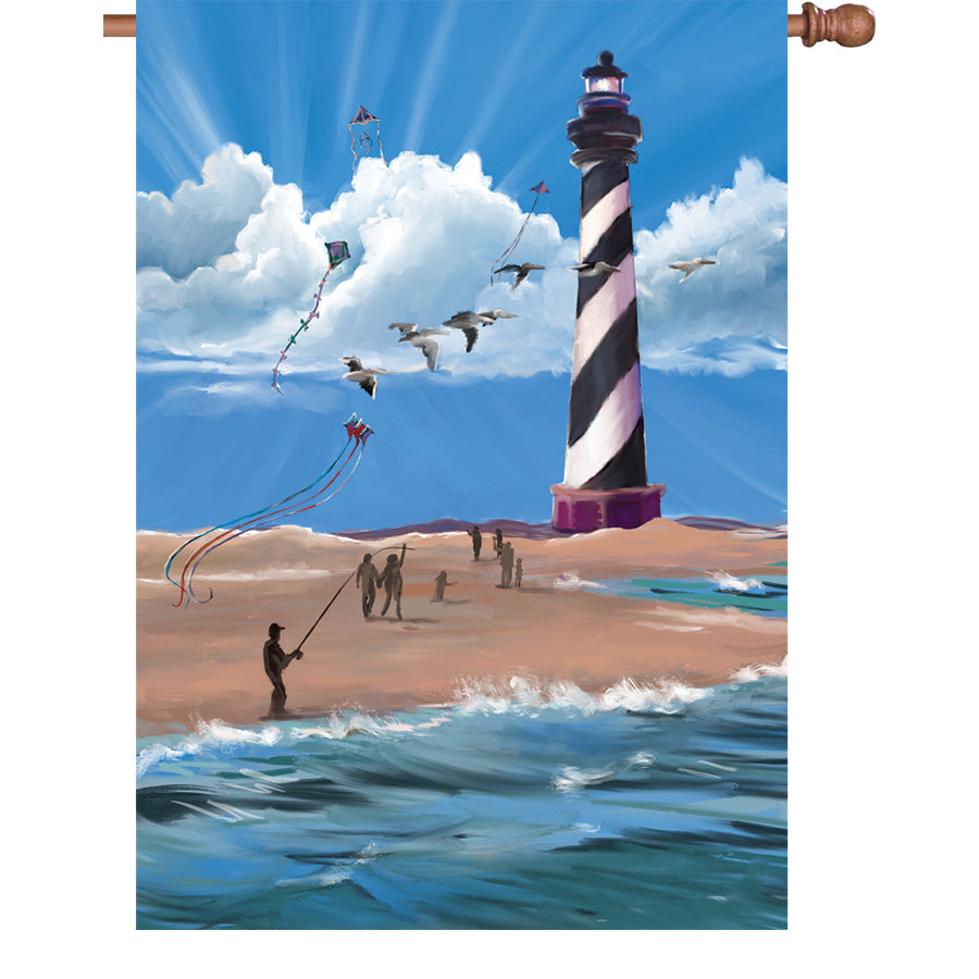 28 in. Hatteras Breezy Day illuminated flag displayed on a flagpole in a lush garden, showcasing its vibrant design against the sunlight.